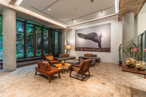 a living room with furniture and a painting on the wall at Penh House Hotel in Phnom Penh