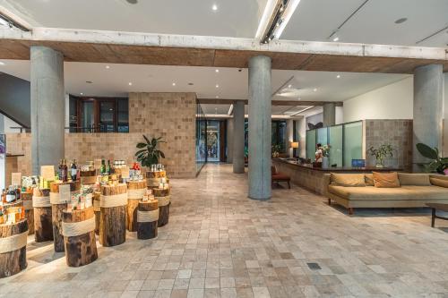a lobby of a building with tables and chairs at Penh House Hotel in Phnom Penh