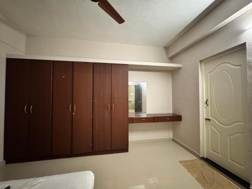 an empty room with wooden cabinets and a door at Nachiyar Suites in Trivandrum