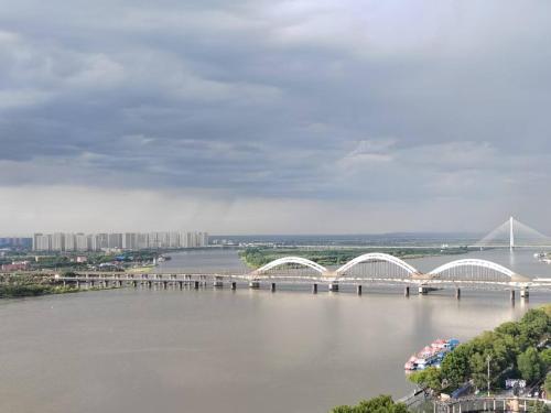 a bridge over a river with a bridge in the background at 比邻中央大街江景公寓 楼下松花江 索道 地铁 防洪纪念塔 in Harbin