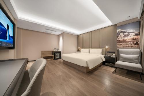 a bedroom with a bed and a flat screen tv at Atour Hotel Chunxi Road Chengdu in Chengdu