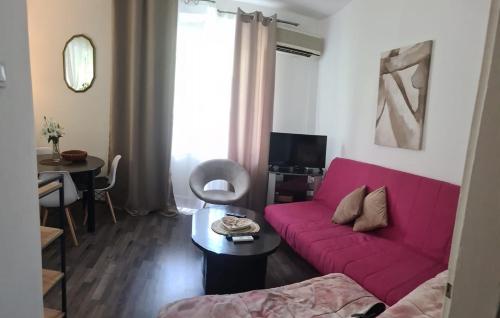 a living room with a pink couch and a table at Coco Apartment in Dobrota