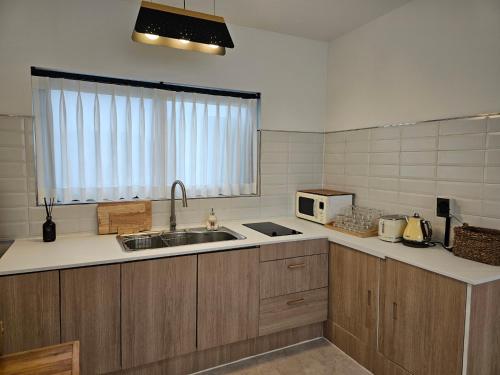a kitchen with a sink and a microwave at Hyupjae Hyun Stay in Jeju
