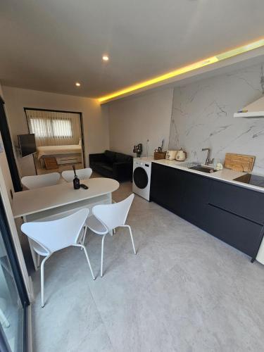 a kitchen and living room with a table and chairs at Hyupjae Hyun Stay in Jeju