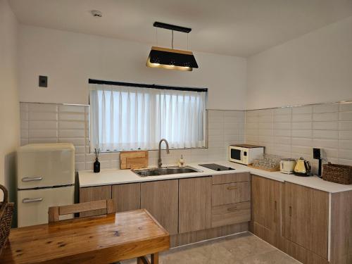 a kitchen with a sink and a refrigerator at Hyupjae Hyun Stay in Jeju