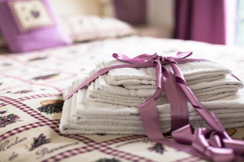 a pile of towels with a purple bow on a bed at Settecentoalberi Agriturismo in Noventa di Piave