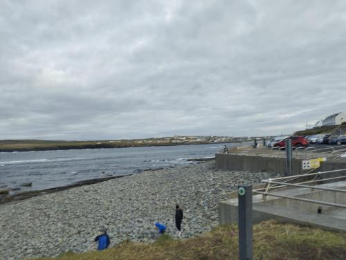 a person walking on a beach near the water at 1 Coirneal chearta in Kilkee