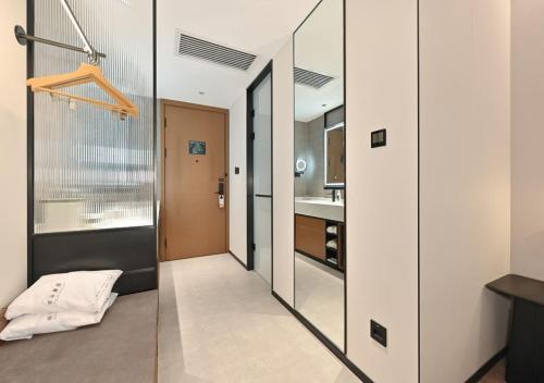 a hallway with a glass door leading to a kitchen at Atour Hotel Beijing South Xizhan Road in Beijing