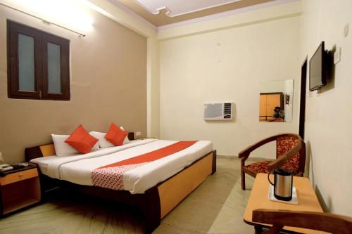 a hotel room with a bed and a chair at Hotel O Sky Inn in Jaipur