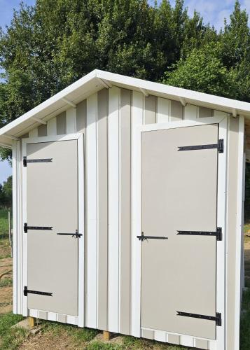 a white garage with two doors on it at Quiétude & Nature in Le Boupère