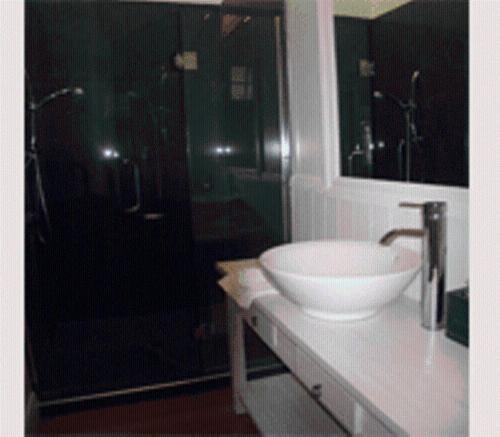 y baño con lavabo y ducha. en Opononi Hotel, en Opononi