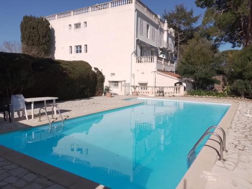 une piscine devant un bâtiment blanc dans l'établissement Au Cœur du Cap d'Antibes pour 2 personnes, à Antibes