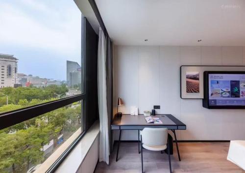 a room with a desk and a large window at Atour Hotel Beijing South Xizhan Road in Beijing
