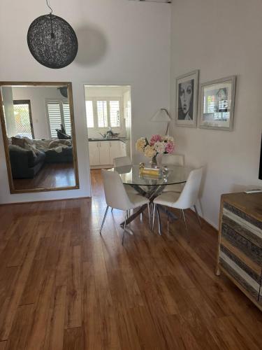 a dining room with a table and chairs and a mirror at Brighton Beach Villa Scarborough in Perth