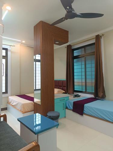 a bedroom with two beds and a blue table at Chiitajyoti Home Stay in Silchar