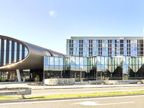a large building with a glass facade and a road at ibis Styles Melbourne Airport in Melbourne