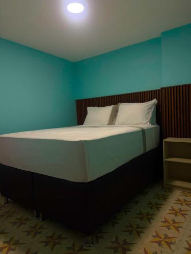 a large bed in a room with a blue wall at Hostel43 in Estación El Salto