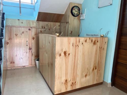 a wooden cabinet in a room with a clock on the wall at AeroVale Lodge in Bīr