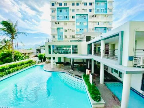 a building with a swimming pool in front of a building at 2 Bedrooms Budget Friendly Condotel in Iloilo City in Iloilo City