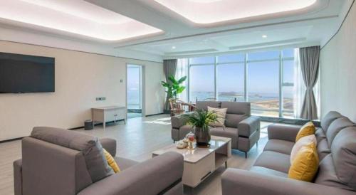 a living room with couches and a flat screen tv at Zhuhai Dehan Hotel in Zhuhai