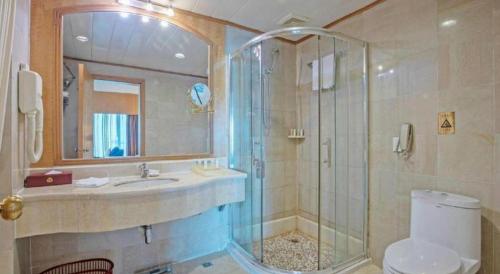 a bathroom with a shower and a sink and a toilet at Zhuhai Dehan Hotel in Zhuhai