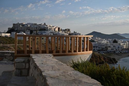 a wooden bench sitting on top of a wall at Iliada Suites in Naxos Chora