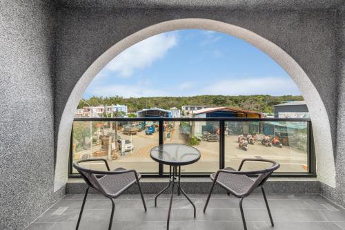 a balcony with a table and chairs and a view at 北極熊旅店 in Xiaoliuqiu