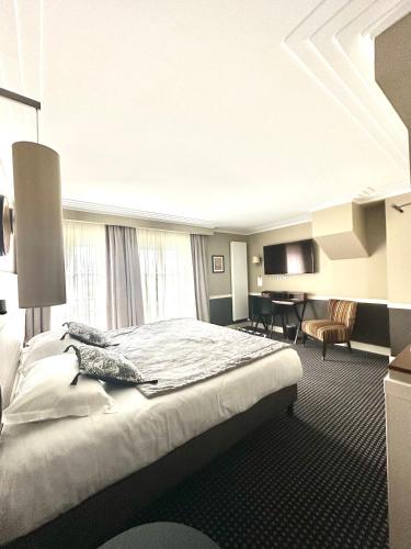 a hotel room with a large bed and a table at Maison Lia in Châlons-en-Champagne