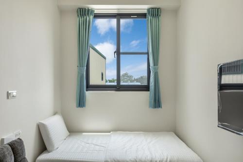 a bedroom with a bed and a window at 北極熊旅店 in Xiaoliuqiu
