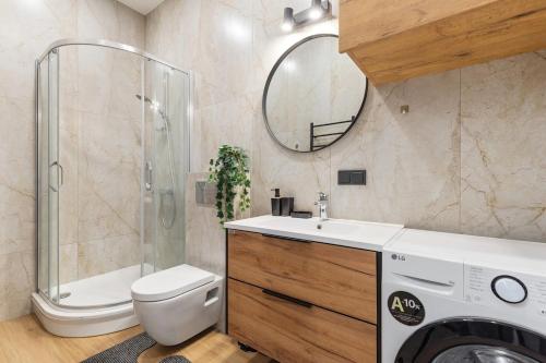 a bathroom with a sink and a shower and a washing machine at Niwaki Sodai No 2 by URBAN RENT in Vilnius