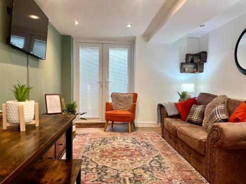 a living room with a couch and a chair at Cherry Blossom cottage in Old Glossop