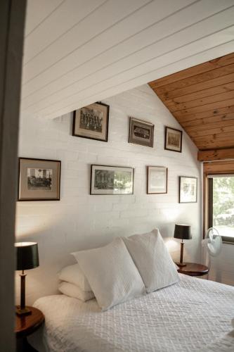 a bedroom with a bed and some pictures on the wall at Crackenback Farm Guesthouse in Crackenback