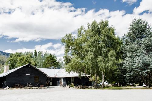 a barn with a tree in front of it at Crackenback Farm Guesthouse in Crackenback