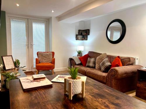 a living room with a couch and a table at Cherry Blossom cottage in Old Glossop
