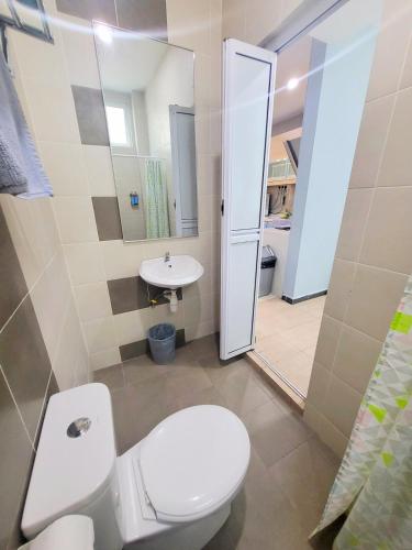 a bathroom with a toilet and a sink at Sunday Villa 14 pax with jacuzzi pool in Ulu Melaka