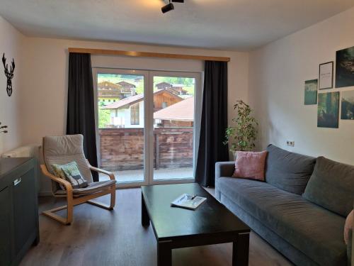 a living room with a couch and a window at Ferienhaus Enzian in Prägraten am Großvenediger