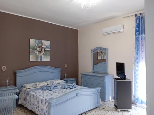 a bedroom with a blue bed and a mirror at Holiday home Carmelo and Daniela in Porto Empedocle