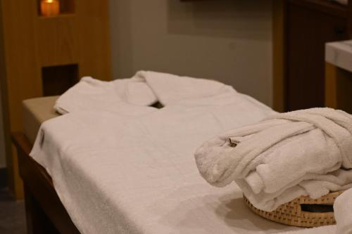 a bed with white sheets and a towel on it at Ambiance Resort Hunza in Hunza