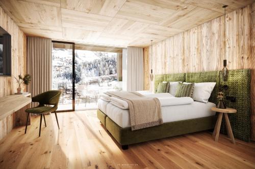 a bedroom with a bed and a desk and a window at Luxury B&B August in Ortisei