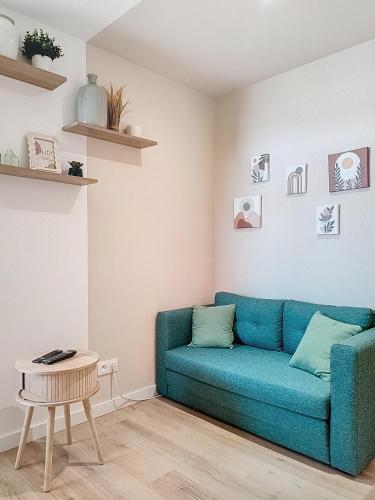 a living room with a blue couch and a table at Studio le Magnolia in Lavaur