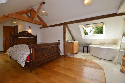 une chambre avec un lit et une baignoire dans l'établissement La Maison de vacances du Doux Verger à Saint Lunaire, à Saint-Lunaire