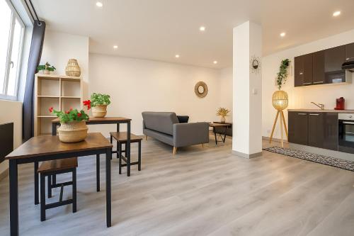 a living room with a table and a kitchen at Le Vosgien - Hyper center - Calme - Wifi - Spacieux in Épinal