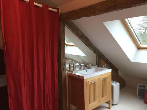 La salle de bains est pourvue d'un rideau de douche rouge et d'un lavabo. dans l'établissement La Maison de vacances du Doux Verger à Saint Lunaire, à Saint-Lunaire