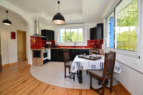 une cuisine avec une table et des chaises dans une pièce dans l'établissement La Maison de vacances du Doux Verger à Saint Lunaire, à Saint-Lunaire