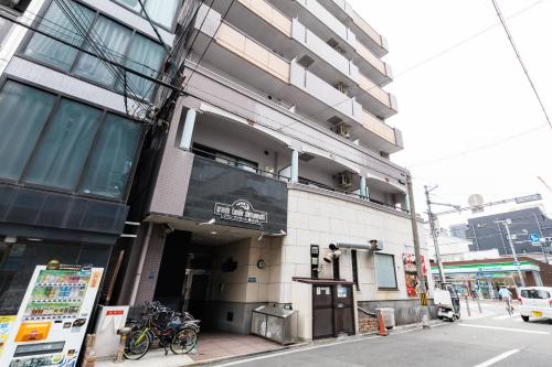 a building on a city street with bikes parked outside at Grande Famille Shimanouchi Dotonbori Condo in Osaka