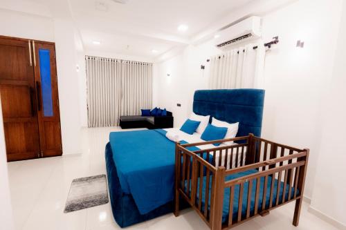 een slaapkamer met een blauw bed en een stoel bij Ransara Resort in Dikwella