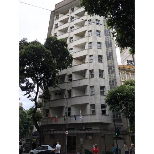 a tall white building with flags on it at Hotel Carioca in Rio de Janeiro