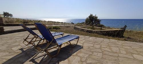 a blue chair sitting on a stone patio near the ocean at Thea Studio Paros in Logaras