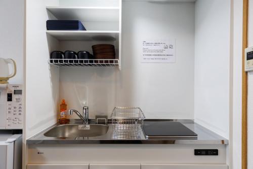 a kitchen with a sink and a counter top at Grande Famille Shimanouchi Dotonbori Condo in Osaka