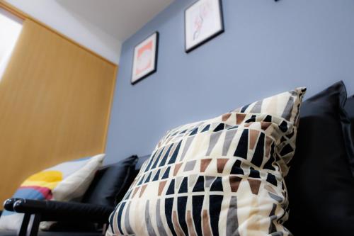 a pillow sitting on a couch in a room at Grande Famille Shimanouchi Dotonbori Condo in Osaka